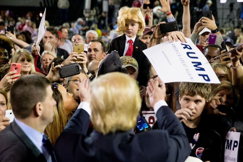 The real Donald Trump gestures to a 5-year-old dressed up as him at a rally in Georgia (AP Photo/Andrew Harnik)